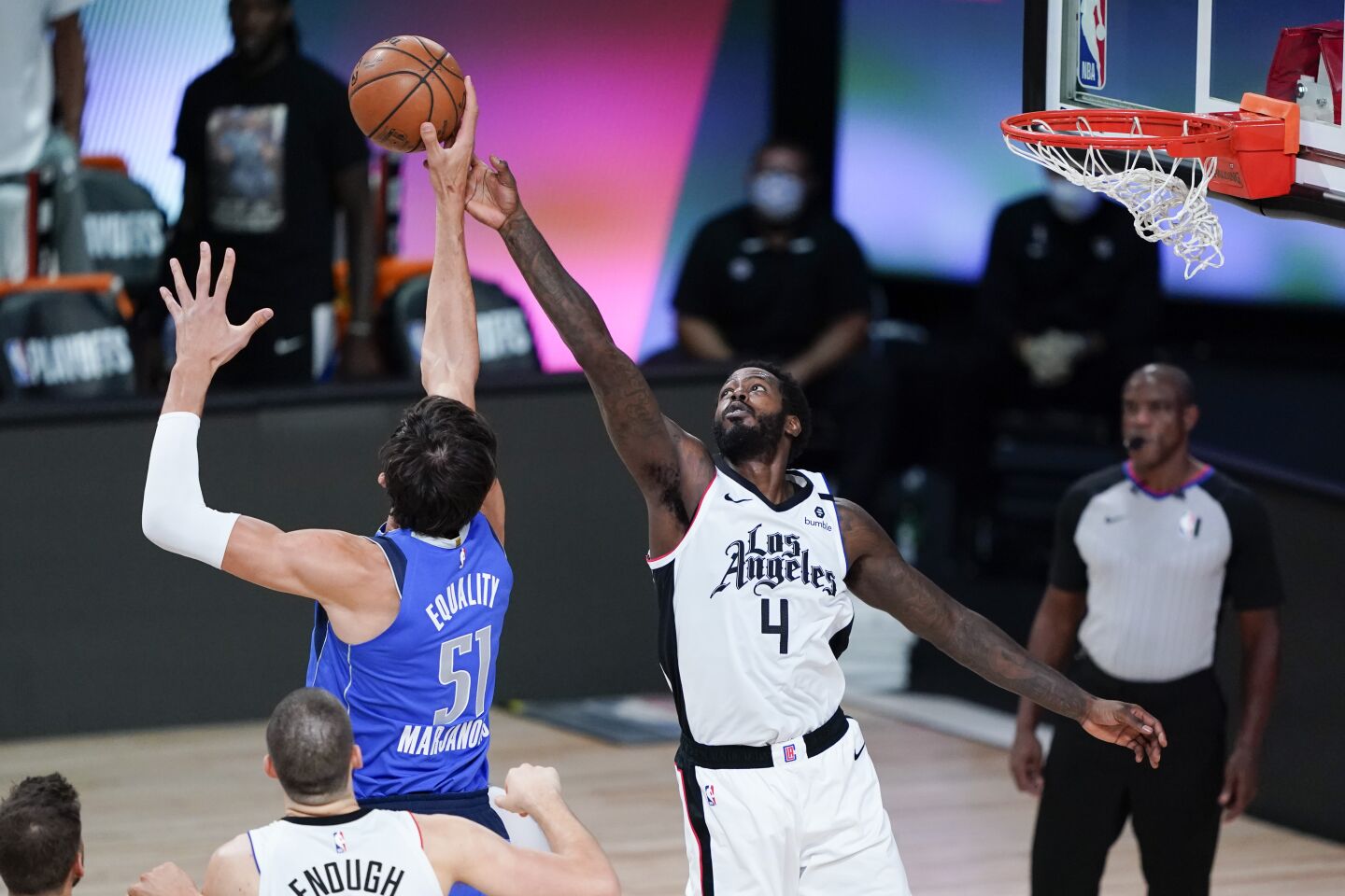 Dallas Mavericks center Boban Marjanovic, left, and Clippers forward JaMychal Green reach for a rebound during Game 3.
