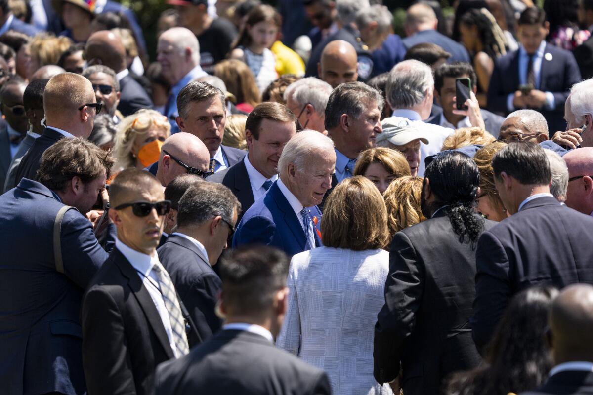 President Biden is surrounded by a crowd.
