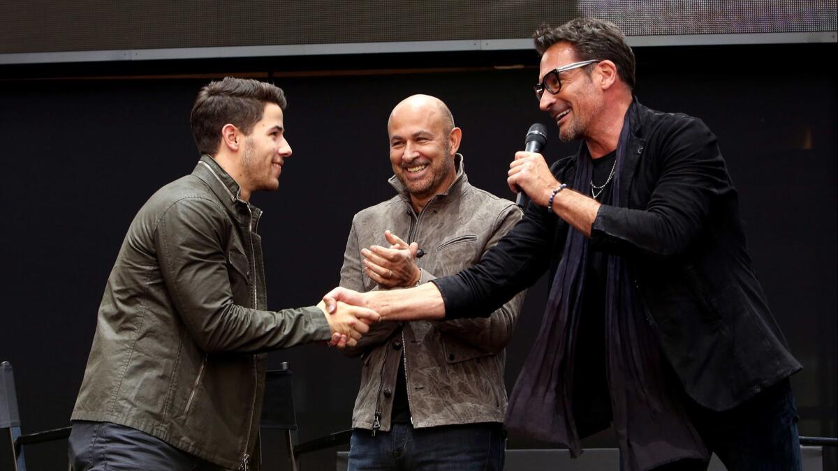 Nick Jonas, left, John Varvatos and Lawrence Zarian onstage at the JV X NJ fragrance event at Westfield Century City in Los Angeles.