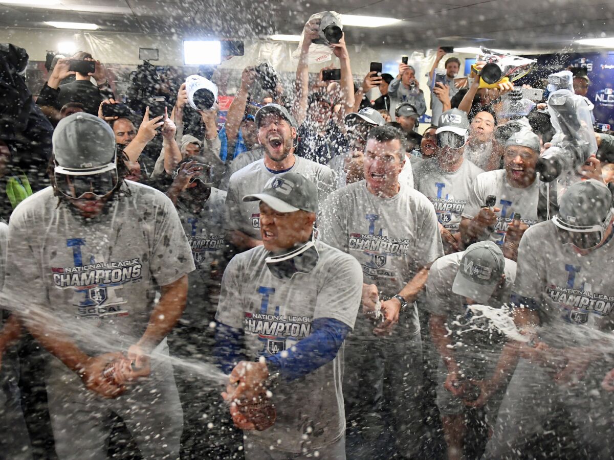 The Dodgers celebrate in the locker room after defeating the Brewers in Game 7 of the National League Championship Series.