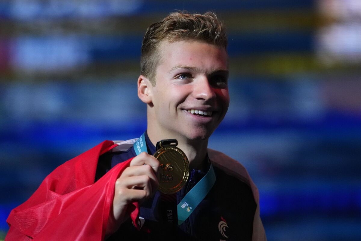 Leon Marchand of France poses with his medal after winning the men's 400m medley final at the 19th FINA World Championships in Budapest, Hungary, Saturday, June 18, 2022. (AP Photo/Petr David Josek)