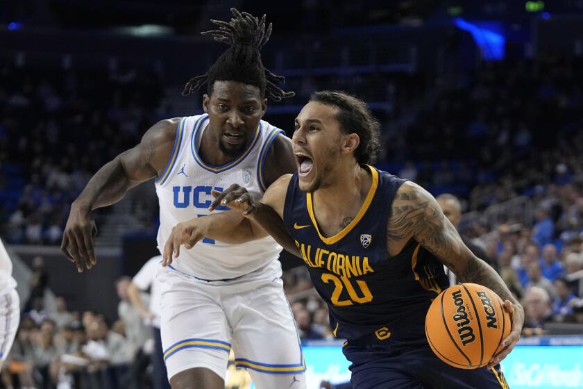 California guard Jaylon Tyson, right, drives to the basket as UCLA forward Kenneth Nwuba.