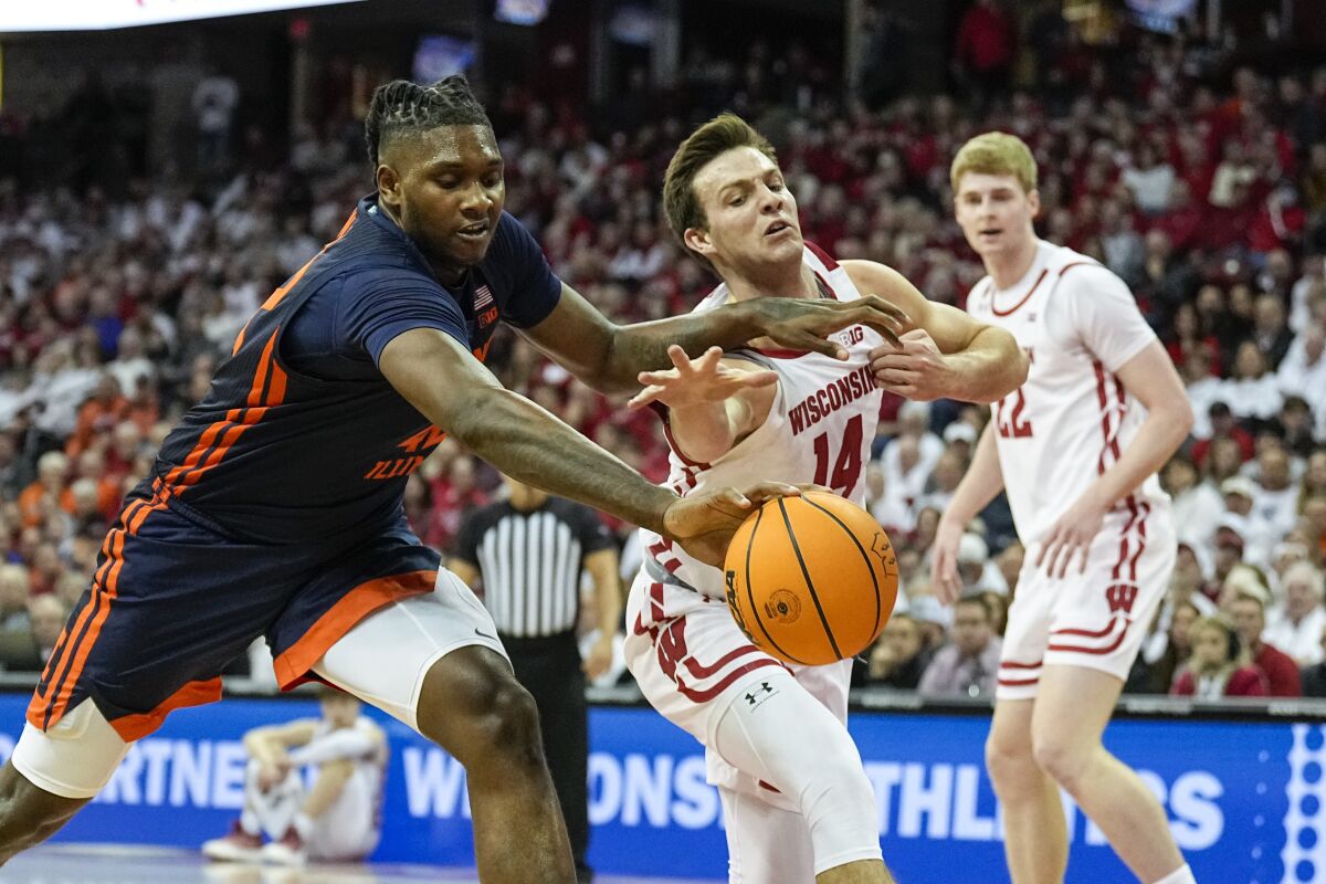 Illinois's Dain Dainja, left, and Wisconsin's Carter Gilmore (14) go after a loose ball during the first half of an NCAA college basketball game, Saturday, Jan. 28, 2023, in Madison, Wis. (AP Photo/Andy Manis)