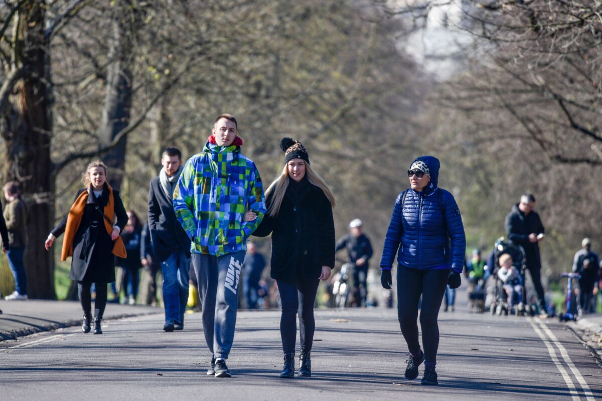People are seen walking in Greenwich Park in London on Sunday.