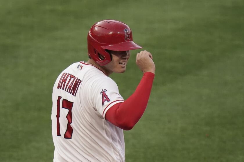 Los Angeles Angels' Shohei Ohtani tips his helmet after reaching first base on a bunt during the sixth inning of a baseball game against the Cleveland Indians, Wednesday, May 19, 2021, in Anaheim, Calif. (AP Photo/Jae C. Hong)