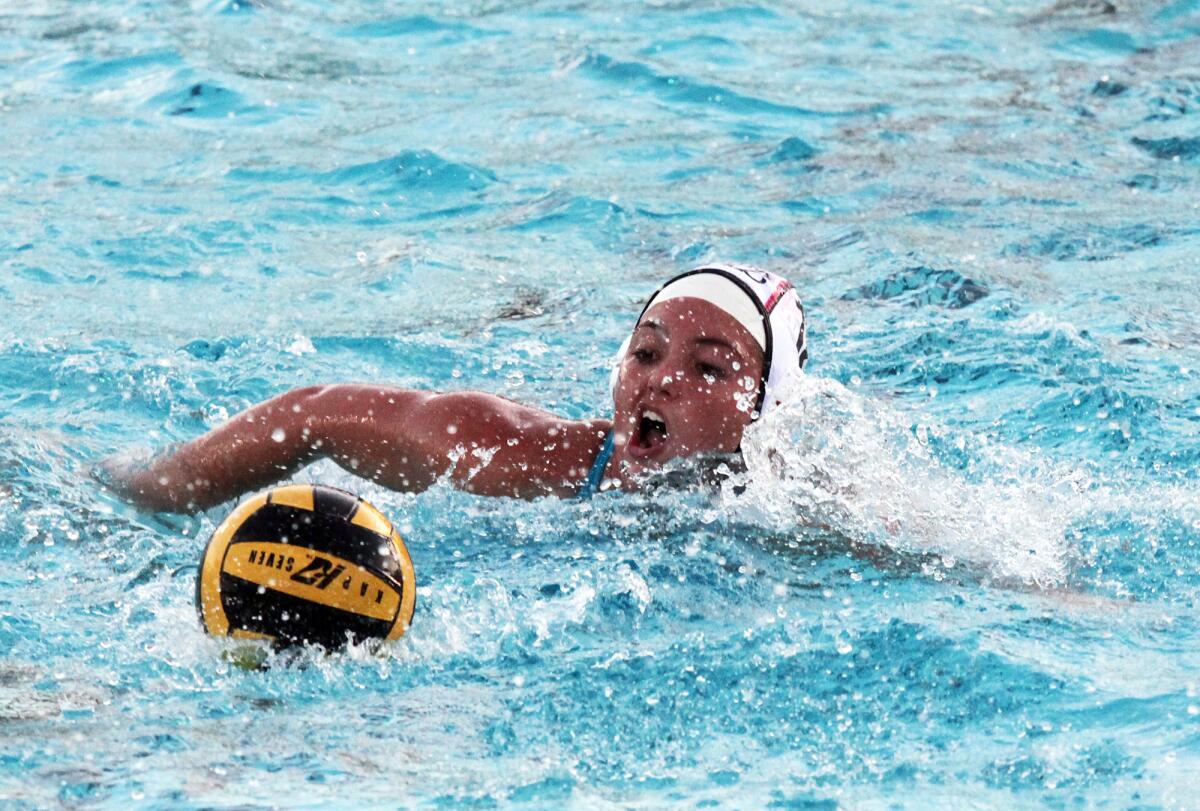 Corona del Mar's Makena Macedo (12) swims the ball down the pool during Wednesday's match.