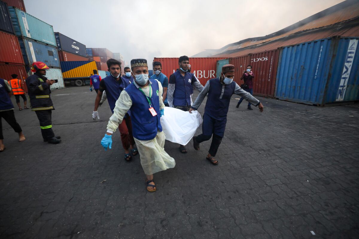 People carry the body of a victim after a fire broke out at the BM Inland Container Depot.