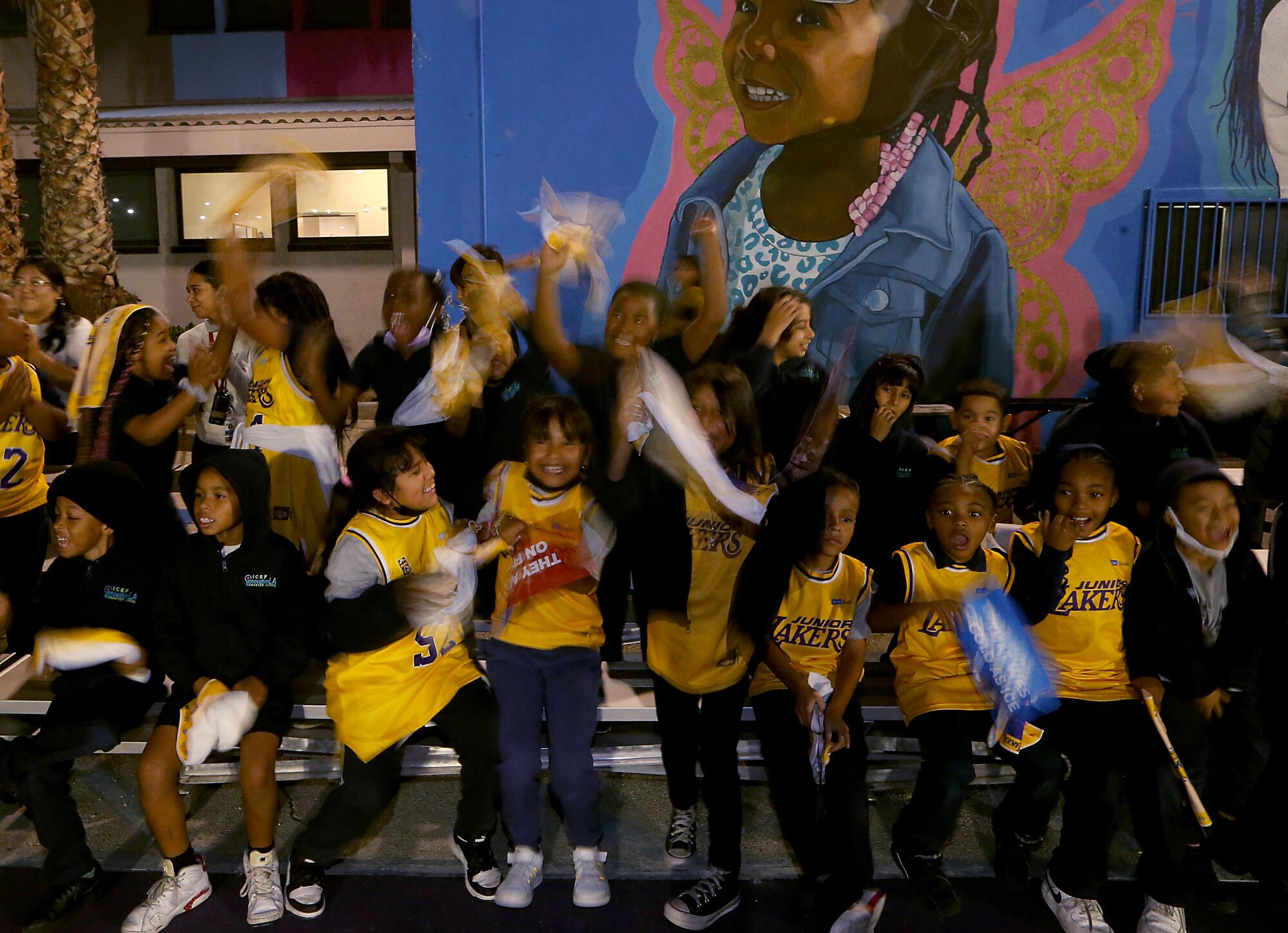 A group of children cheer during the unveiling of a new basktball court at the Challengers Boys & Girls Club.