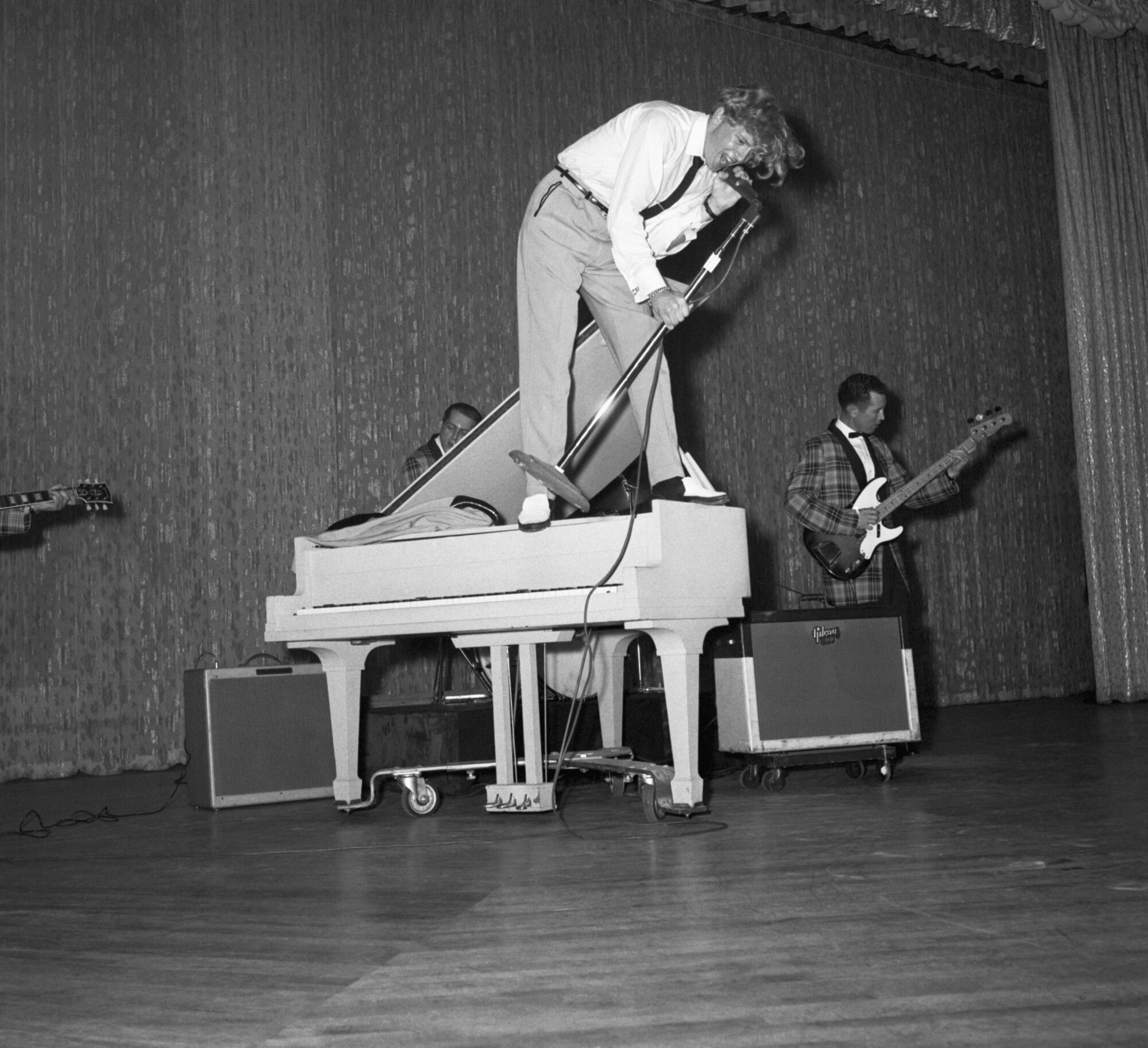 Bir piyanonun üzerinde duran rock 'n' roll şarkıcısı Jerry Lee Lewis, Haziran 1958'de coşkulu bir performans sergiliyor.
