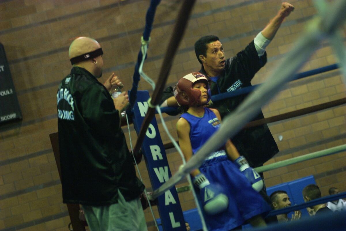 Seneisa Estrada has been active on the Southland boxing circuit for more than a decade. An 11-year-old Estrada stands in the corner in this 2004 file photo while her father, Joe, signals to the referee during the Silver Gloves Regional Boxing Tournament.