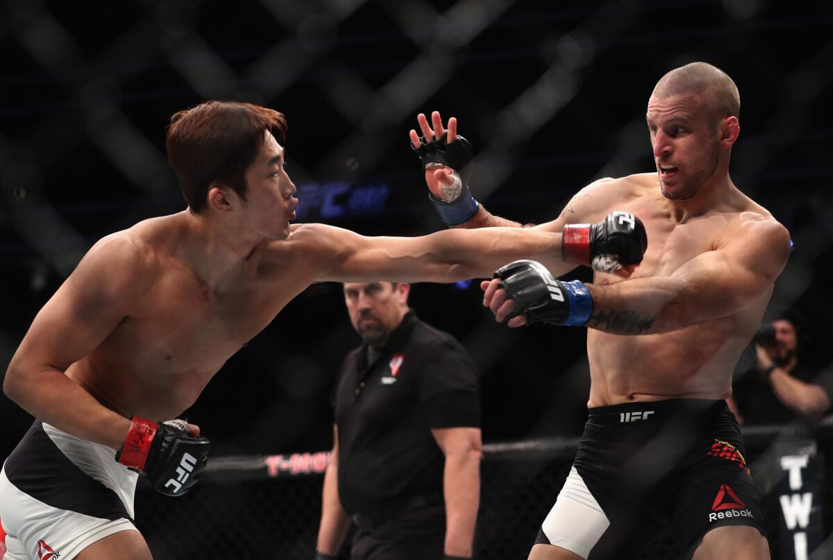 Dong Hyun Kim and Tarec Saffiedine trade punches during their welterweight bout at UFC 207.