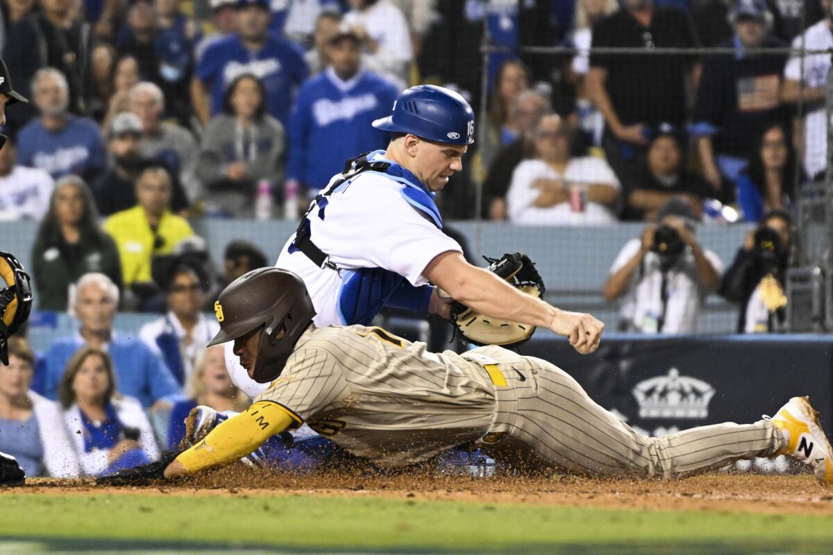 San Diego's Ha-Seong Kim slides into home plate past Dodgers catcher Will Smith in the fifth inning.