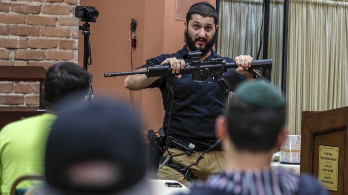 Rabbi Raziel Cohen holds an AR-15 rifle while delivering information and tips on how to deal with an active shooter to members of a Los Angeles synagogue.