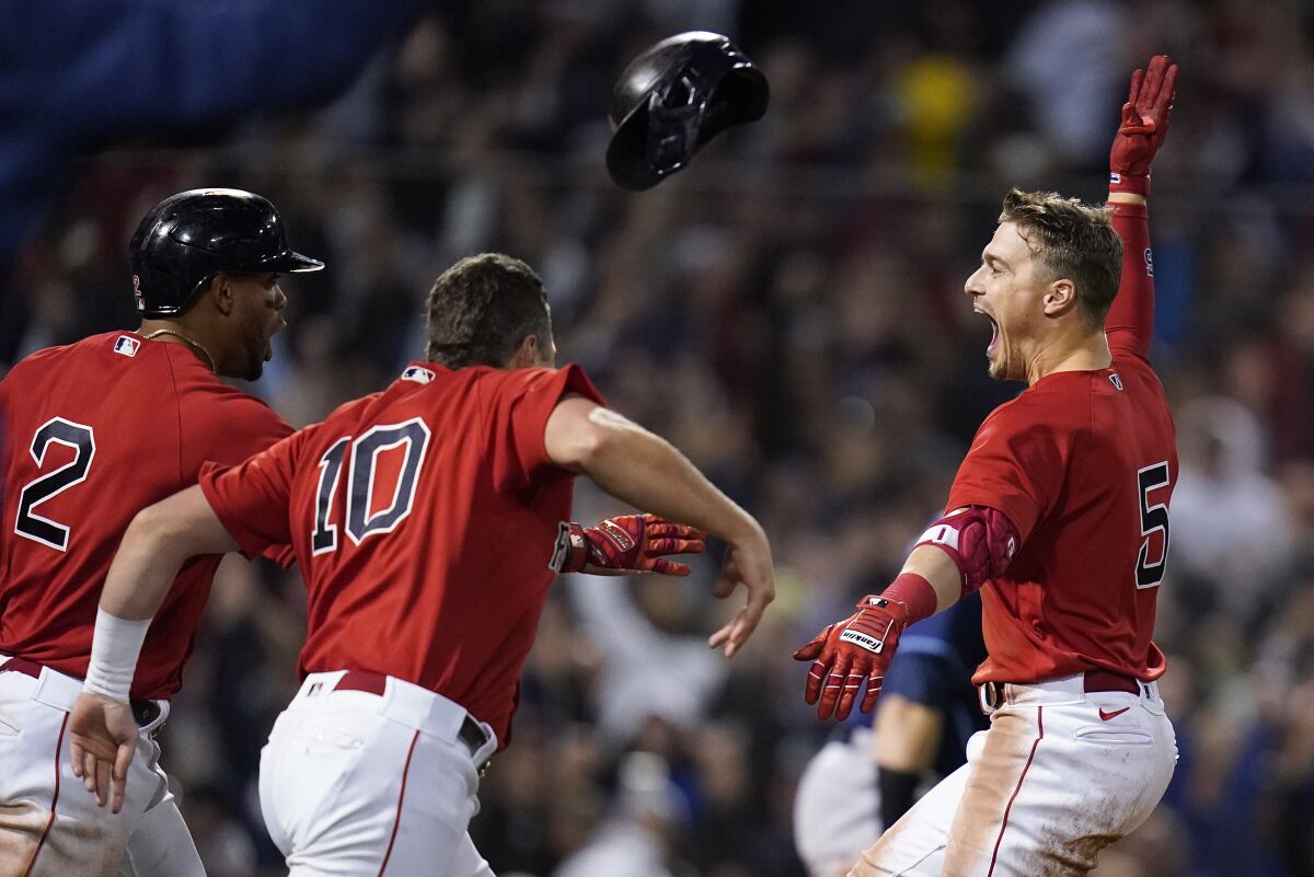 Boston Red Sox Enrique Hernandez, right, celebrates with teammates after hitting a sacrifice fly ball to score Danny Santana to beat the Tampa Bay Rays in the ninth inning during Game 4 of a baseball American League Division Series, Monday, Oct. 11, 2021, in Boston. The Red Sox won 6-5. (AP Photo/Charles Krupa)