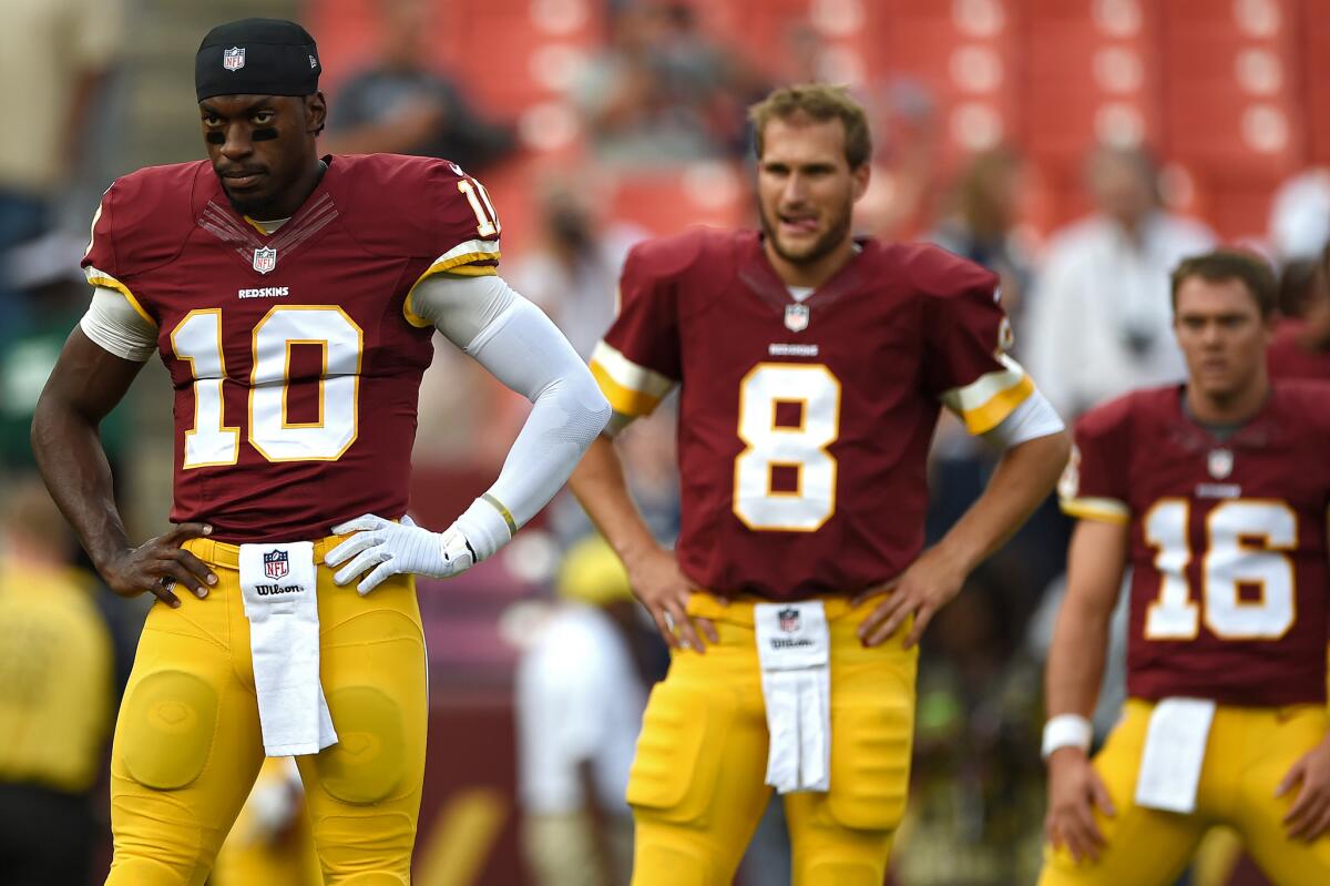 Washington quarterbacks Robert Griffin III, left, and Kirk Cousins watch during a preseason game against New England on Aug. 7.