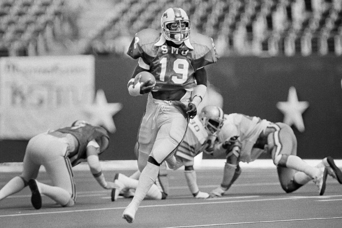FILE - SMU's Eric Dickerson (19) runs the ball against against Rice during the first half of an NCAA college football game at Texas Stadium in Irving, Texas, Nov. 7, 1981. The former SMU running back, who played for the Mustangs from 1979-82, was one of 27 players invited to the Tuesday, Dec. 7, 2021, induction ceremony for the College Football Hall of Fame in Las Vegas. Dickerson was voted into the 2020 class, but the ceremony was canceled due to the pandemic. (AP Photo/David Breslauer, File)