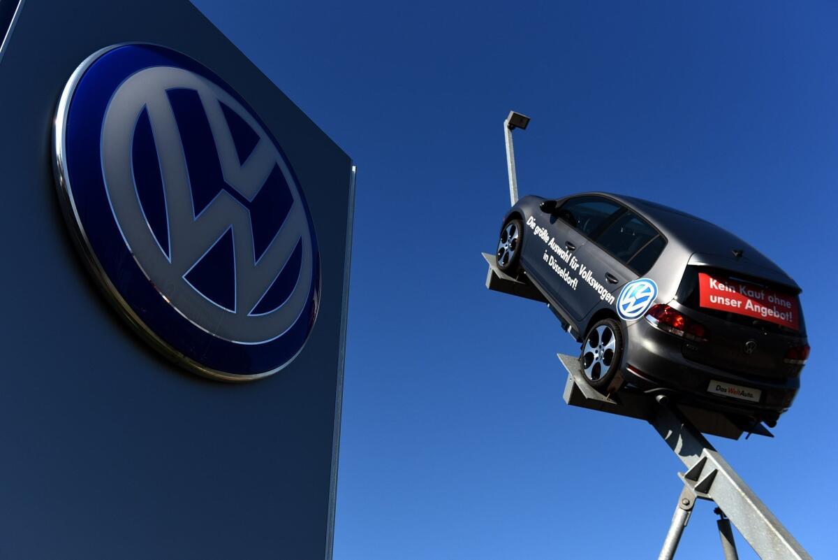 A picture taken on September 28, 2015, shows a model and logo of German car maker Volkswagen (VW) at the entrance to a VW branch in Duesseldorf, western Germany.