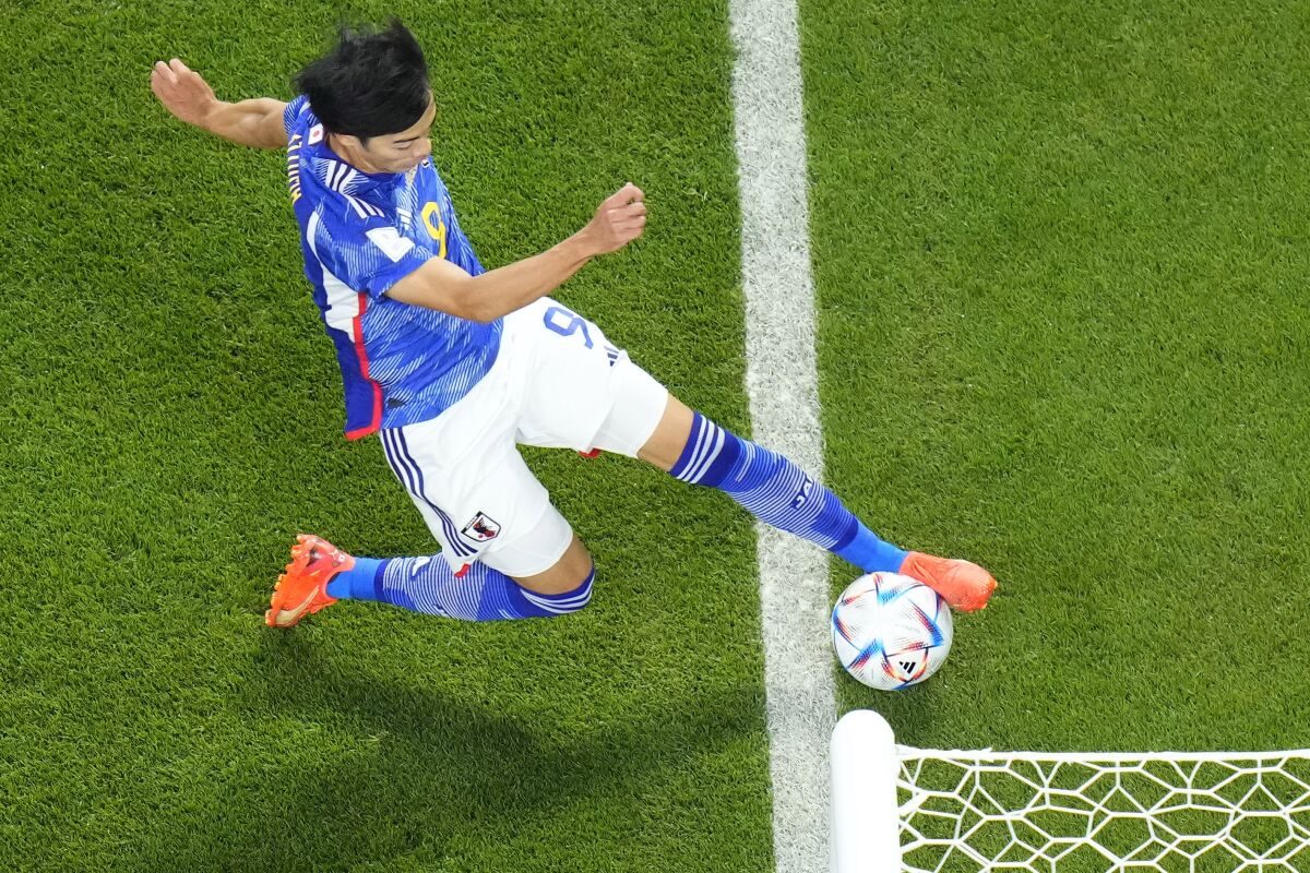 Japan's Kaoru Mitoma appears to have the ball over the line before crossing it for a goal during the World Cup group E soccer match between Japan and Spain, at the Khalifa International Stadium in Doha, Qatar, Thursday, Dec. 1, 2022. (AP Photo/Petr David Josek)