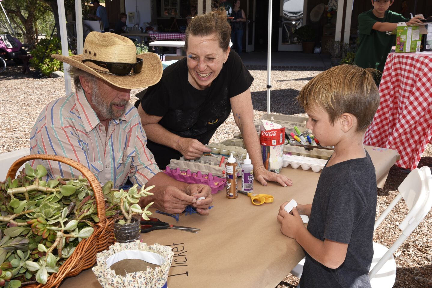 101 Artists’ Colony President Danny Salzhandler, Kristi Stone, and Braxton at one of the many hands on craft stations