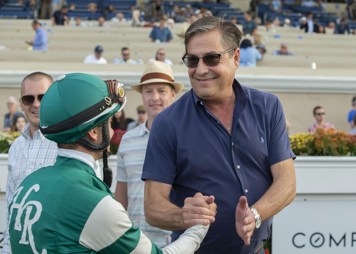 Trainer John Sadler, right, celebrates with jockey Flavien Prat, left, after Higher Power's victory in the Grade I, $1,000,000 Pacific Classic horse race on Saturday at Del Mar Thoroughbred Club.