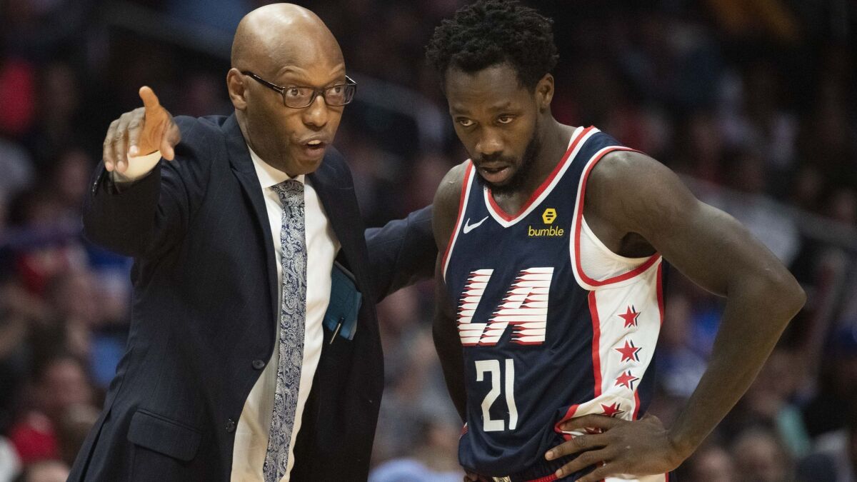 Clippers assistant coach Sam Cassell talks to guard Patrick Beverley during a game against the Denver Nuggets on Dec. 22.