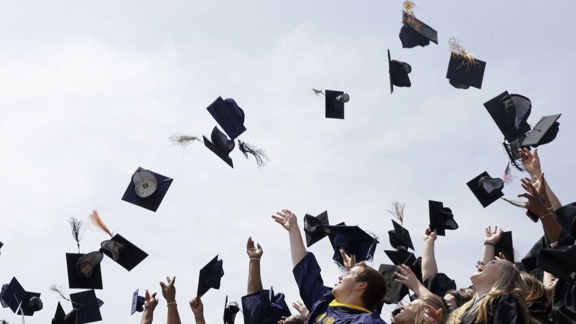 College graduates throw their caps into the air. Approximately 1 in 4 adults in the United States holds student debt.