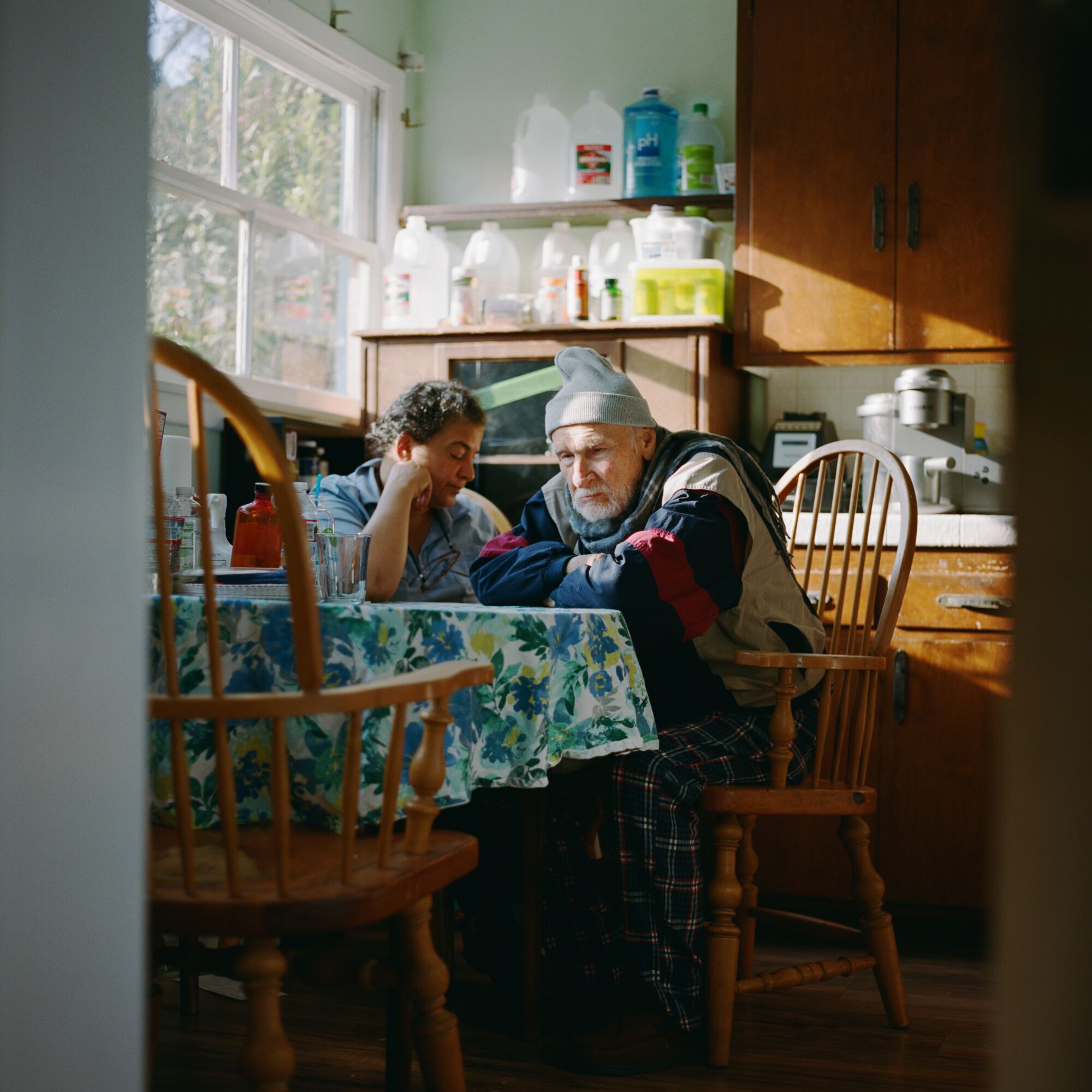 Andrzej, right, and his caretaker sit at the dining room table in the Stefanski family home.