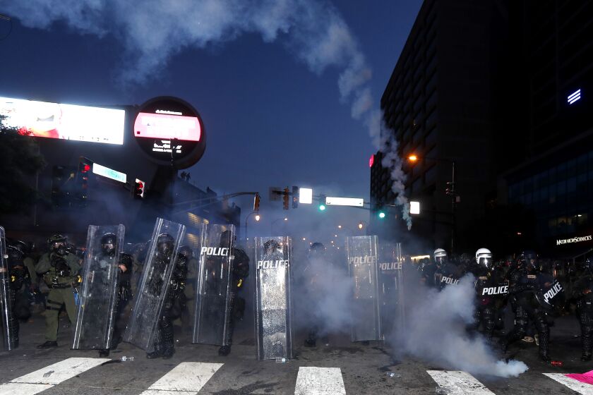 Atlanta police prepare to enforce a curfew with gas as demonstrators chant, Tuesday, June 2, 2020, in Atlanta.