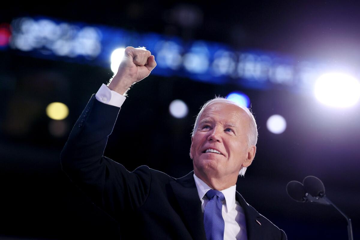 President Biden raises his fist onstage.