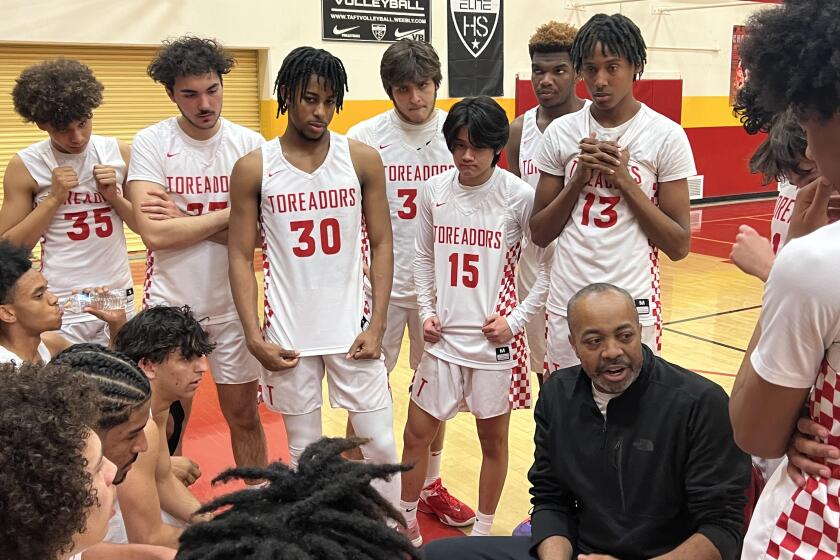 Taft coach Derrick Taylor talks to his team during timeout Fridiay night against King/Drew