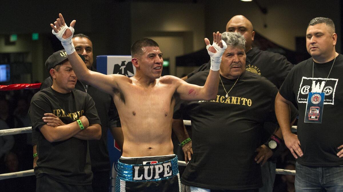 Guadalupe Arroyo of Huntington Beach and his team react as opponent Mauricio Gomez of Santa Ana was named the winner after a four-round junior lightweight bout during Fight Club OC at The Hangar in Costa Mesa on Thursday.