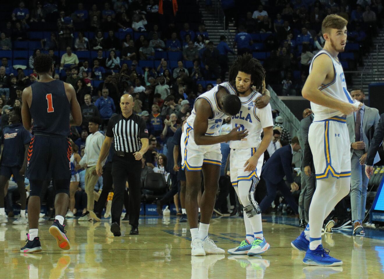 WESTWOOD, CA - DECEMBER 28, 2019: UCLA Bruins guard Tyger Campbell (10) consoles UCLA Bruins guard Prince Ali (23) after Ali turned the ball her in the final seconds of the Bruins 77-74 loss to Cal State Fullerton at Pauley Pavilion on December 28, 2019 in Westwood, California.(Gina Ferazzi/Los AngelesTimes)