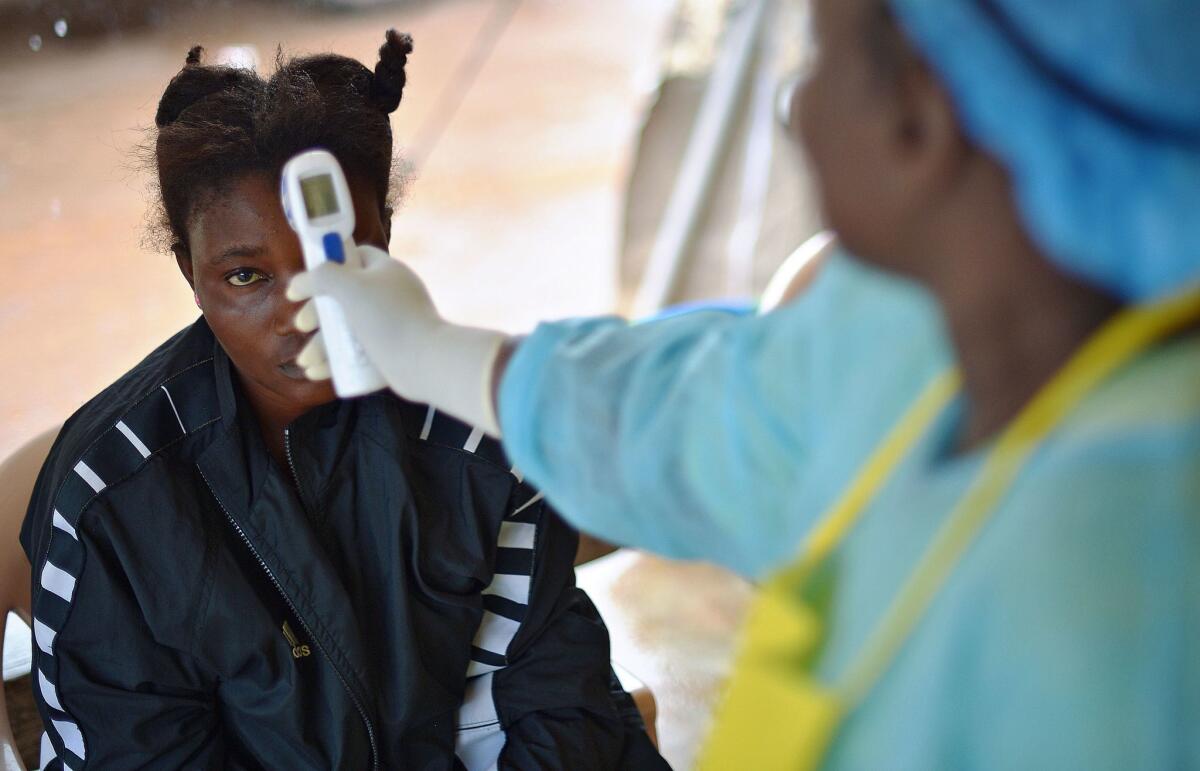 A girl suspected of being infected with the Ebola virus has her temperature checked at a government hospital in Kenema, Sierra Leone, on Aug. 16.