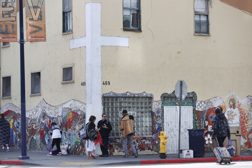 SAN DIEGO, CA - MARCH 25: Homeless people stand outside the God's Extended Hand Ministries on the corner of Island Avenue and 16th Street on Thursday, March 25, 2021 in San Diego, CA. The center, which has offered homeless services for 40 years, is facing several code violations and may have to shut down. (K.C. Alfred / The San Diego Union-Tribune)