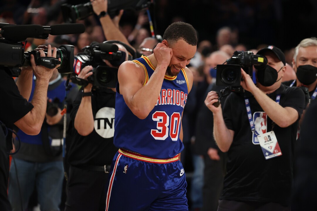 Stephen Curry is surrounded by cameras after making a three-point basket to break Ray Allen’s record.