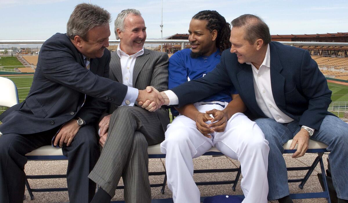 Agent Scott Boras, right, shakes hands with then GM Ned Colletti, who is next to owner Frank McCourt, during a news conference to announce an agreement on a new two-year contract for Manny Ramirez, second from right.