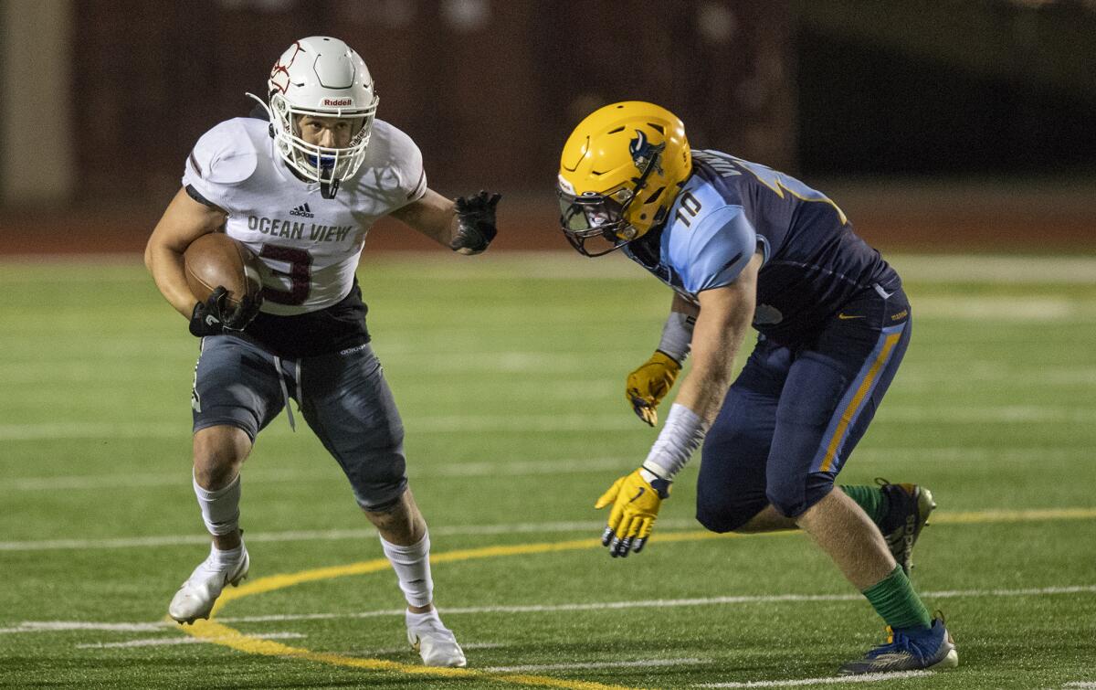 Ocean View's Anthony Ramirez runs the ball under pressure from Marina's Wyatt McClour during a game on Wednesday, March 17.