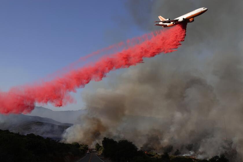 An aircraft drops fire retardant near Lyons Valley Road during the Valley Fire on Sunday.