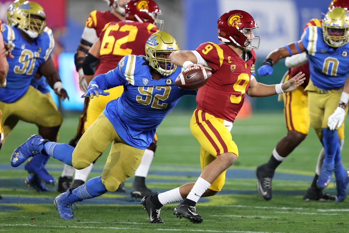 UCLA's Osa Odighizuwa pressures USC quarterback Kedon Slovis on Dec. 12, 2020.