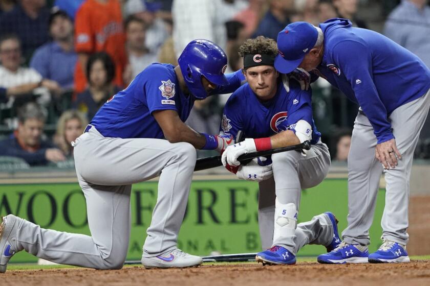 Chicago Cubs' Albert Almora Jr., center, takes a knee as Jason Heyward, left, and manager Joe Maddon, right, talk to him after hitting a foul ball into the stands during the fourth inning of a baseball game against the Houston Astros Wednesday, May 29, 2019, in Houston. (AP Photo/David J. Phillip)