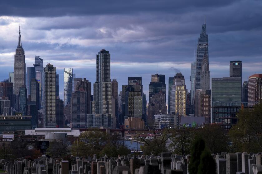 FILE - The sun sets behind the New York skyline, Sunday, Nov. 13, 2022, as seen from Calvary Cemetery. New York will move forward with its first-in-the-nation plan to charge drivers extra in tolls to enter the core of New York City, part of an effort to reduce congestion, improve air quality and raise funds for the city's public transit system. The program is expected to begin in spring of 2024. (AP Photo/Julia Nikhinson, File)