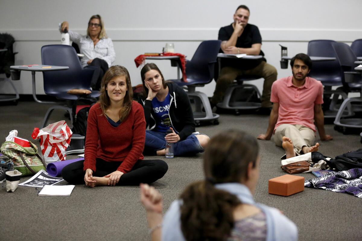 Estudiantes de primer año de la maestría en yoga escuchan a la maestro Ana Funes en la Universidad Loyola Marymount, en Los Ángeles. (Gary Coronado / Los Angeles Times)