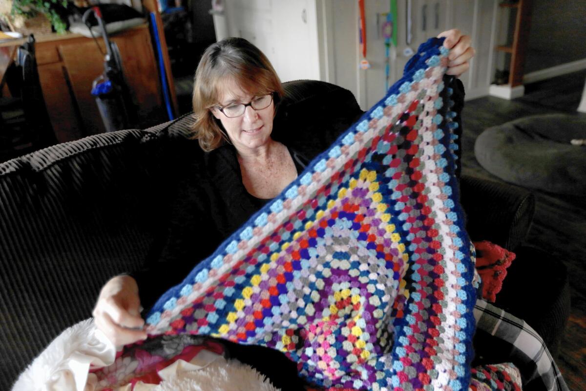 Julie Swann-Paez folds a handmade blanket someone sent her after she was shot twice at the Inland Regional Center on Dec. 2.