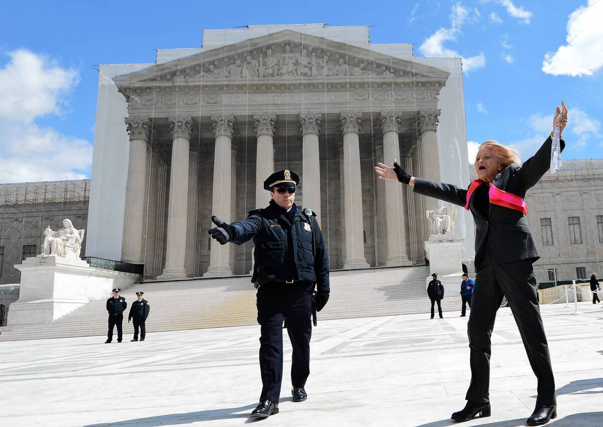 Edith Windsor, a lesbian widow whose case is being heard by the Supreme Court, gestures to supporters outside.