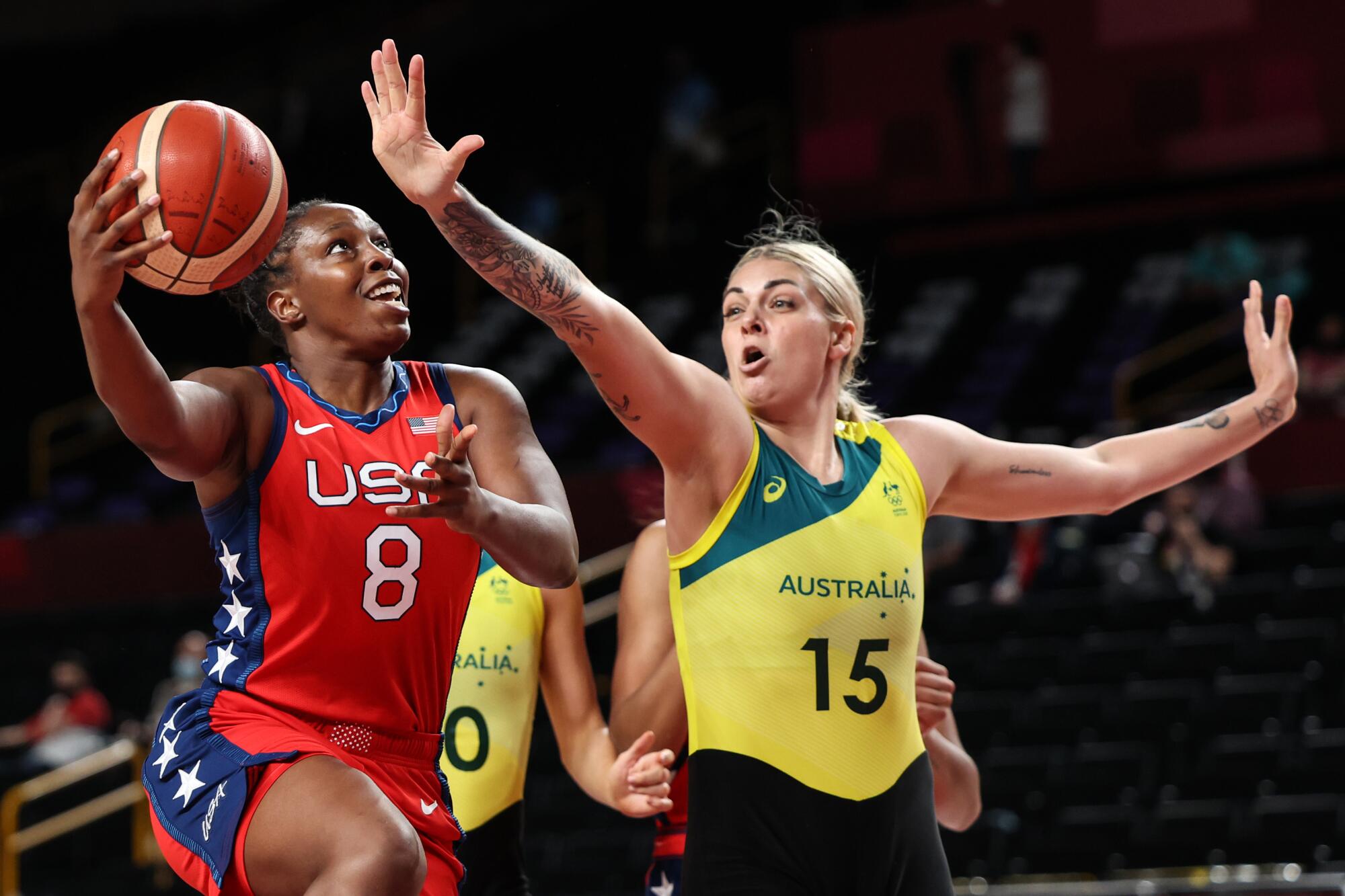 Chelsea Gray drives past Australia power forward Cayla George at the Tokyo Olympics.