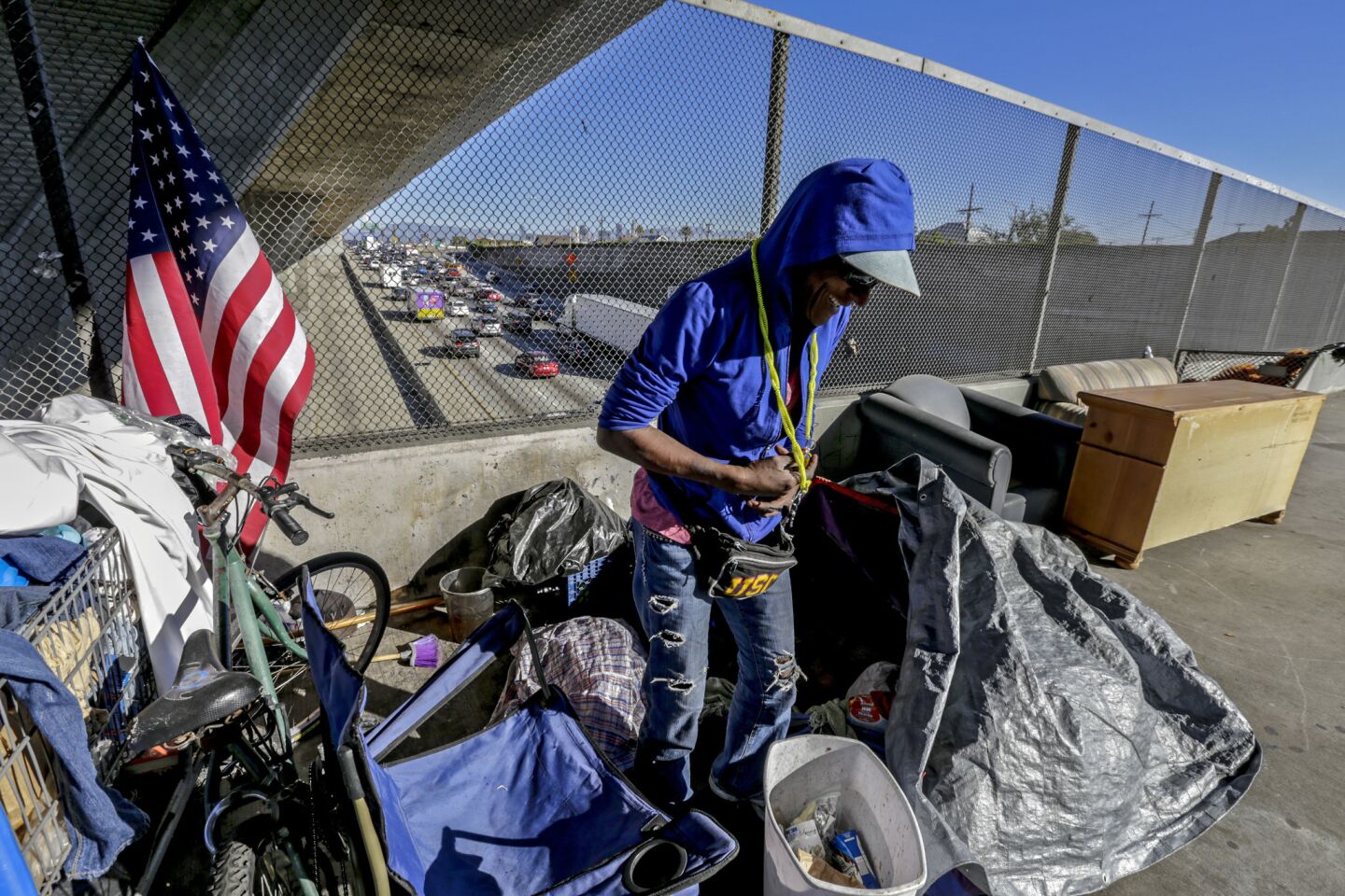 Alice Myles, 60, who is homeless, steps out of her tent pitched over 42nd. Street bridge over 110 Freeway in Los Angles.
