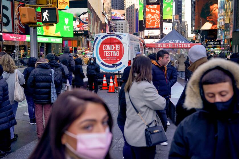 People wait in a long line to get tested for COVID-19 in Times Square.