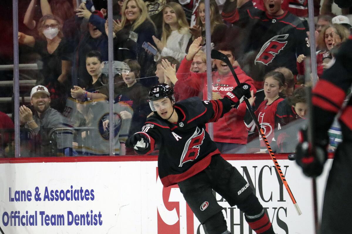 Carolina Hurricanes center Sebastian Aho (20) and Hurricanes fans celebrate after he scored his third goal of the night, during the third period of the team's NHL hockey game against the Buffalo Sabres on Friday, Nov. 4, 2022, in Raleigh, N.C. (AP Photo/Chris Seward)