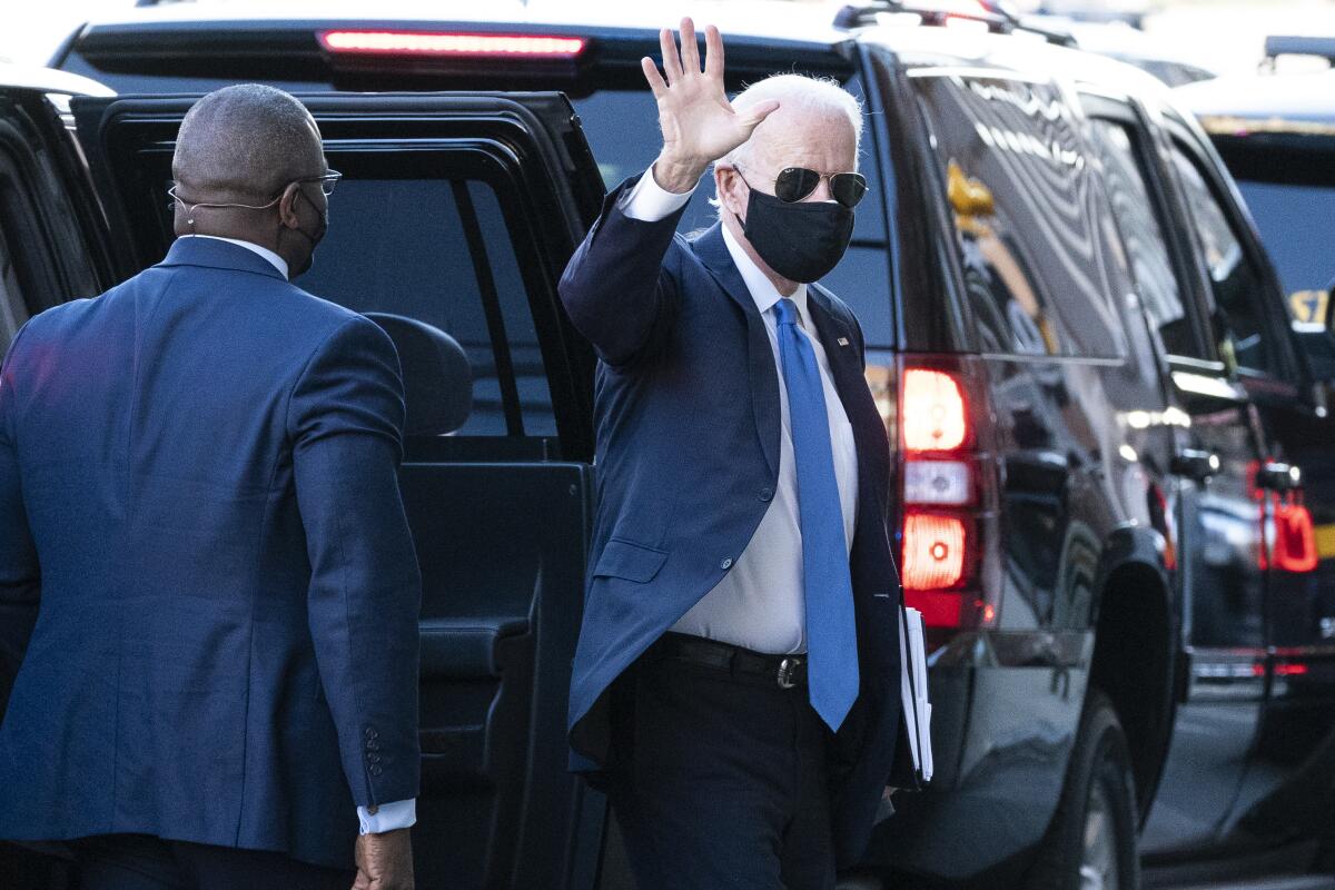 President-elect Joe Biden stands next to his vehicle as he waves 