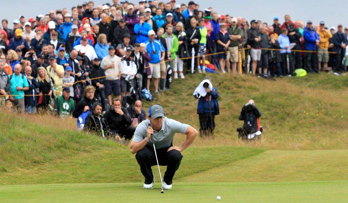 Rory McIlroy lines up his putt on the 11th green as spectators are packed on a hill behind him during the third round of the Open Championship on Saturday at Royal Liverpool in Hoylake, England.